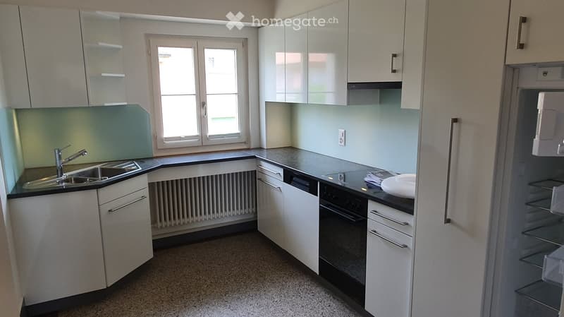Modern kitchen with white cabinets, stainless steel appliances, and a sleek countertop.