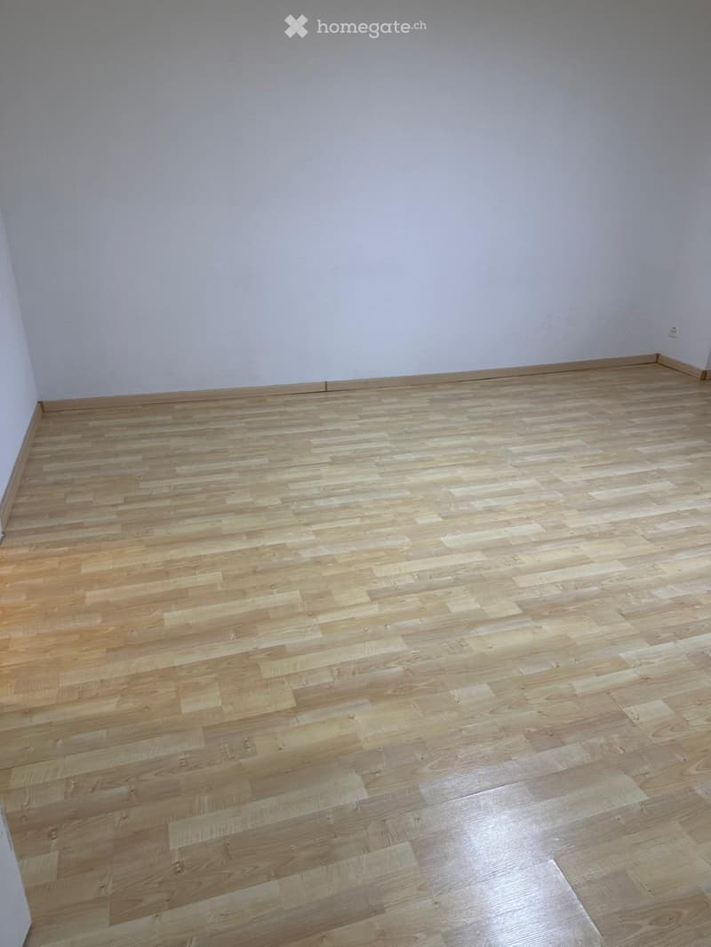 Empty room with light wooden flooring and white walls, no furniture or equipment present.
