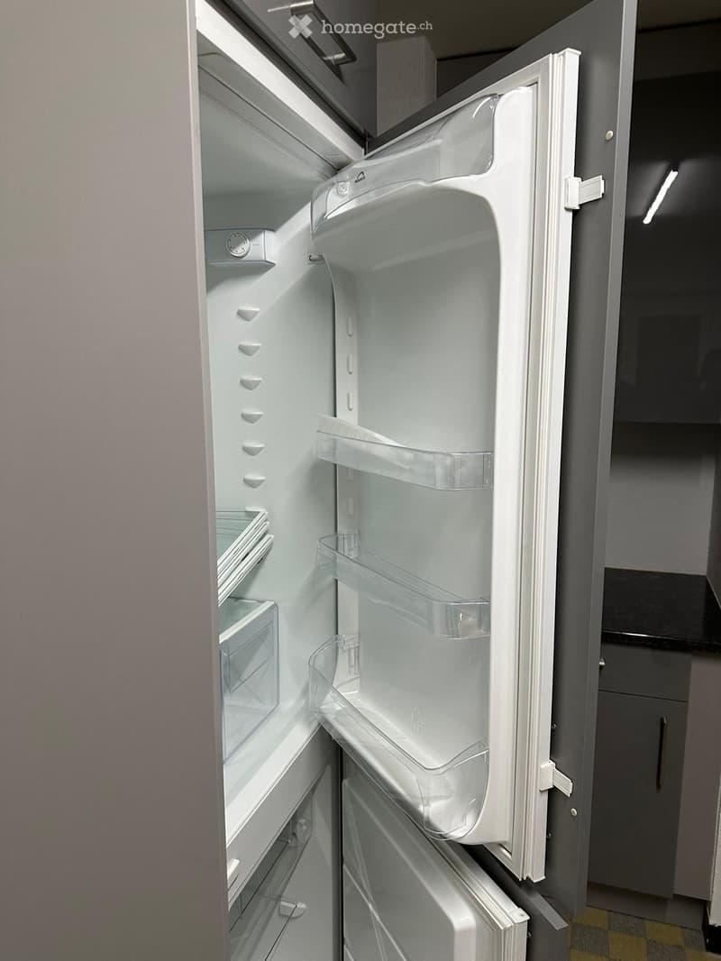 Open refrigerator with multiple shelves and compartments, featuring a modern design with white interior and black exterior.
