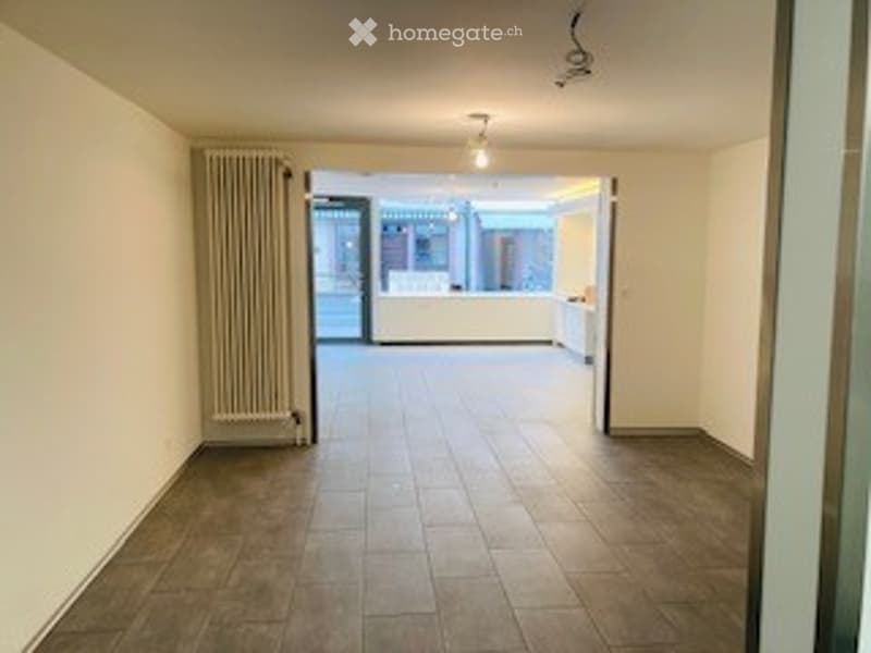 Empty room with tiled floor, white walls, and a radiator on one side. No furniture or equipment visible.