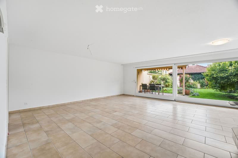 Empty room with tiled floor and large sliding glass doors leading to an outdoor area with a dining set.