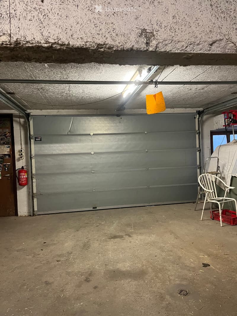 {"visible_features": ["Garage"], "type": "Garage", "objects": ["chair", "fire extinguisher"], "description": "Empty garage with a large closed garage door, a single chair, and a fire extinguisher on the wall.", "localized_descriptions": {"EN": "Empty gara