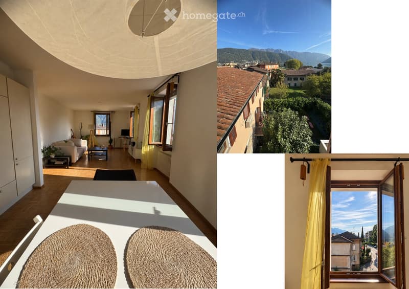 Bright living room with large windows offering scenic views, furnished with a sofa, coffee table, and a dining area with a round table and woven chairs.