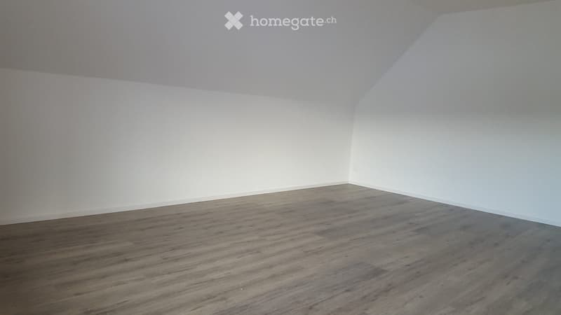 Completely empty room with bare white walls and wooden flooring. No furniture or equipment.