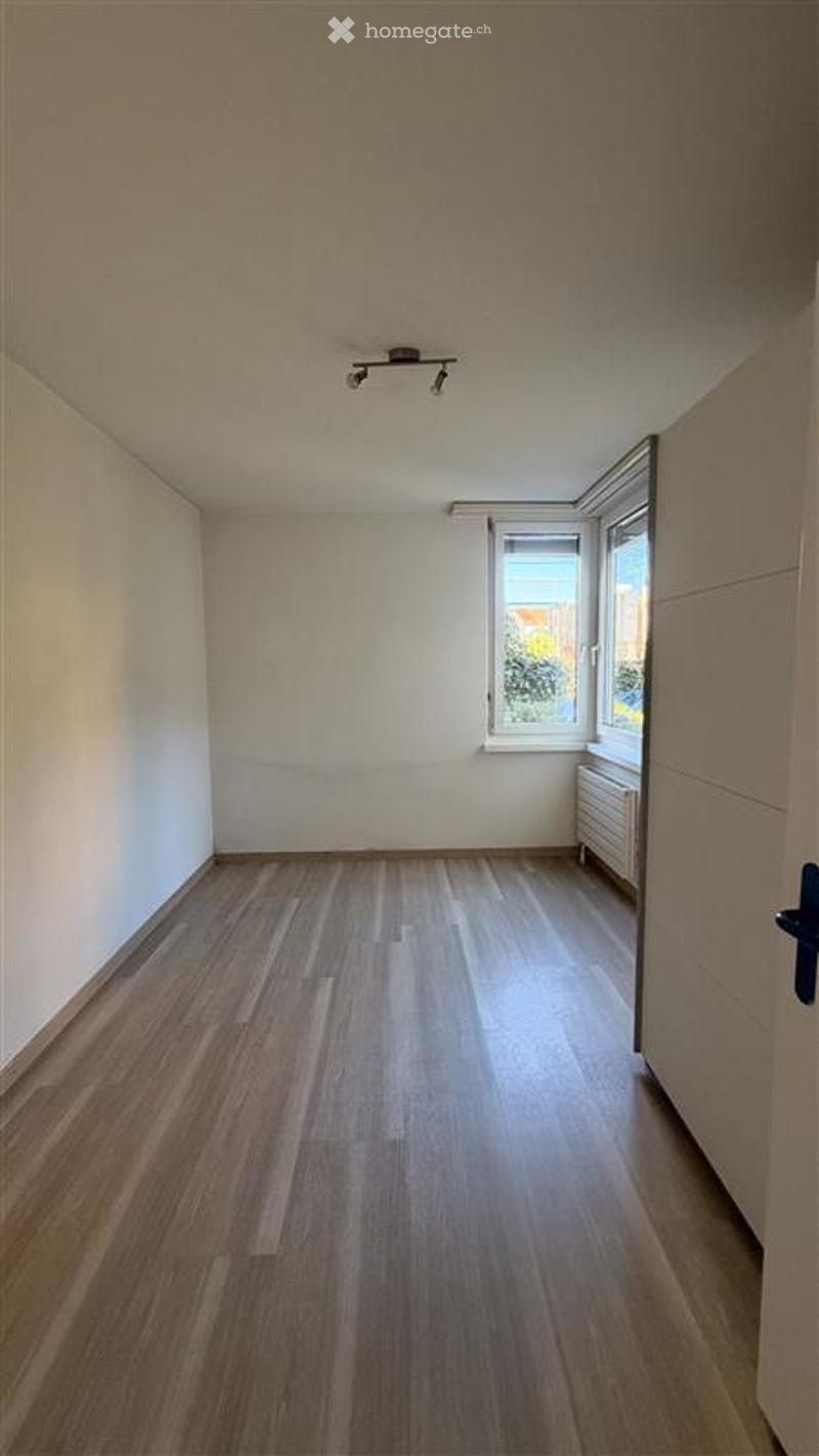 Empty room with wooden flooring, white walls, and a window with blinds. No furniture or equipment present.
