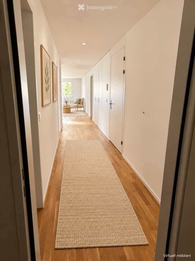 A modern hallway with light wooden flooring, white walls, built-in white cabinetry, and a long beige woven runner. A small seating area with a chair and coffee table is visible at the end of the hallway, along with framed artwork on the walls.