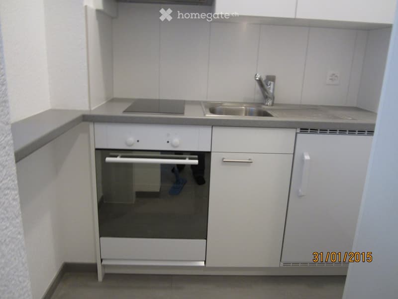Kitchen. Compact kitchen with white cabinets, an oven, a sink, and a faucet.
