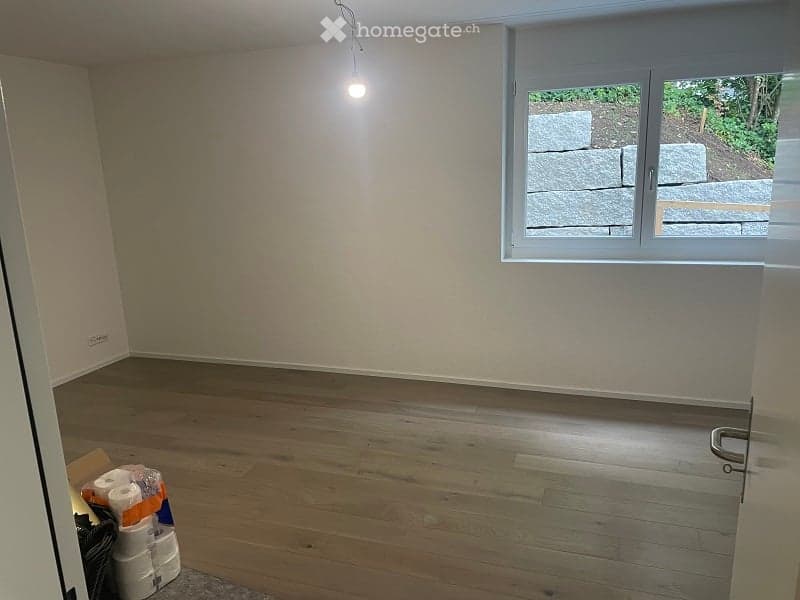 empty room, white walls, wooden floor, window with white frame, light coming from the window