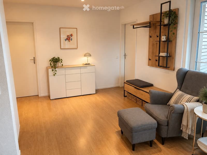 Modern living room with light wooden flooring, grey sofa with ottoman, side table, white cabinet, small lamp, wooden shelf with plants, and a framed picture on the wall.