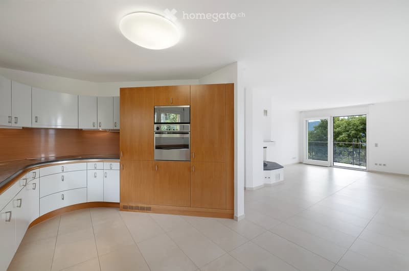 Modern kitchen with white cabinets, wooden countertops, and stainless steel appliances.