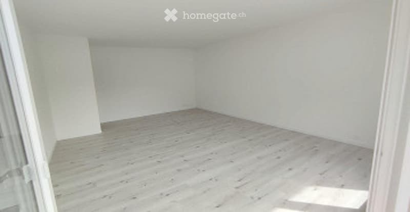Completely empty room with light wooden flooring and white walls. No furniture or equipment.