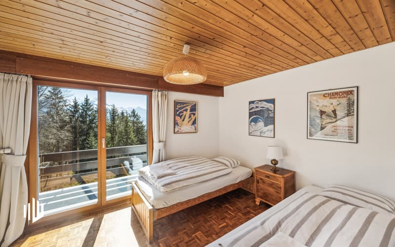 Zimmer im Obergeschoss mit Zugang auf den Balkon