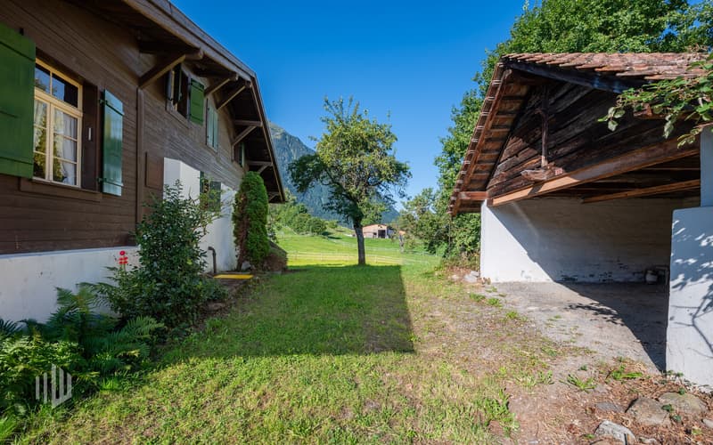 Zugang zum Haus, rechts davon Schopf/gedeckte Parkplätze