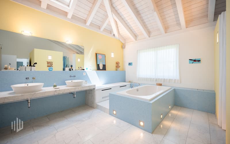 Badezimmer mit offener Badewanne, Dusche und 2 einzelnen Lavabos