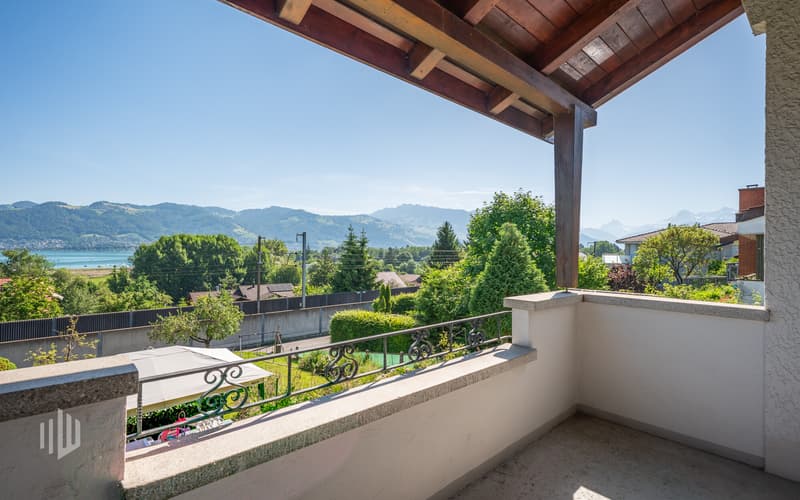 Gedeckter Balkon mit See- und Bergsicht, welche die Bahngeleise wettmachen