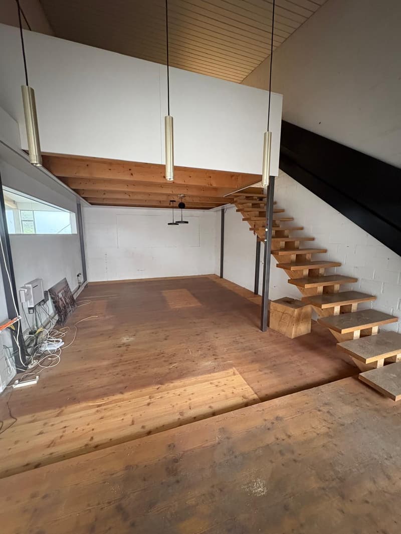 Raised ground floor, wooden floors, wooden stairs, exposed ceiling beams, white walls, large window