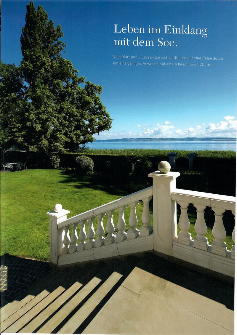 white wooden railing, green lawn, large tree, beach and ocean visible