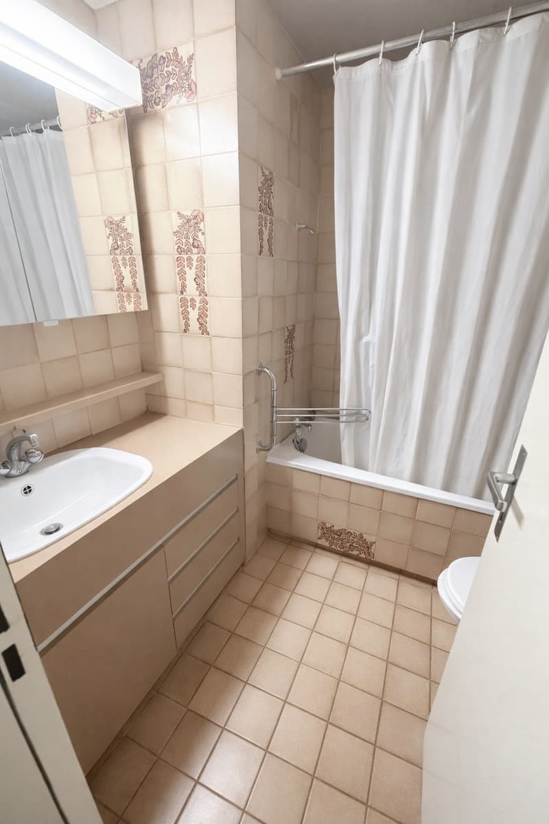Bathroom with sink, bathtub, toilet, tiled floor, wall-mounted mirror, shower curtain