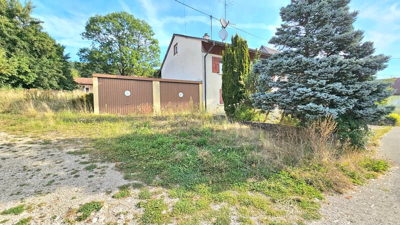 Two-story house, beige walls, brown garage, trees, satellite dish, grass field