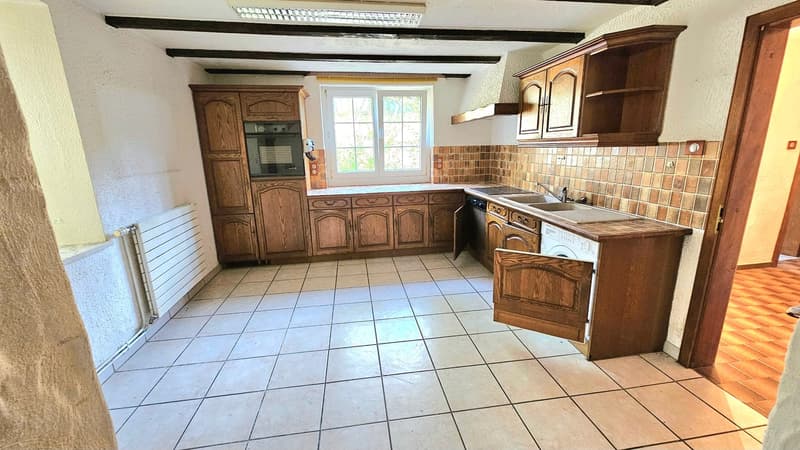 white tiled floor, brown wooden cabinets, sink with faucet, oven built into wall, window, white radiator