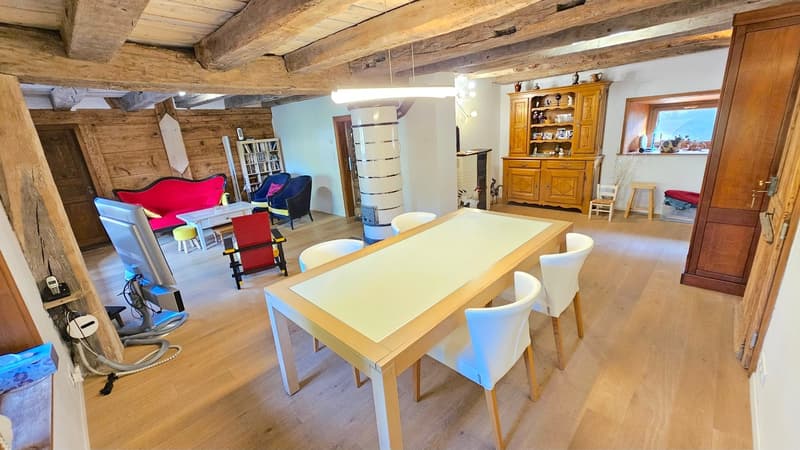 Dinning room, wooden floor, dining table, white chairs, bookshelf, wooden cabinet, couch, center table, stools, heater