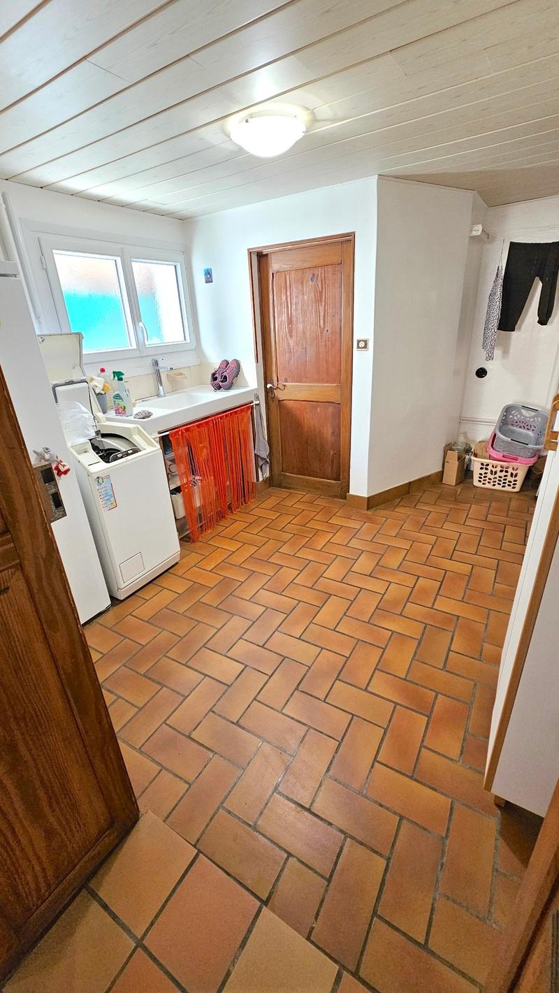 white ceiling, brick floor, white washing machine, red curtains, white sink, white refrigerator, wooden door