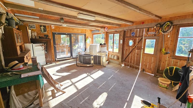 a storage shed with shelves, white refrigerator, kitchen tools, a foldable chair, and a desk