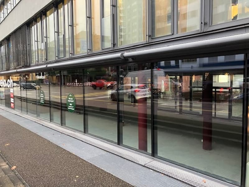 A modern glass facade building with large windows