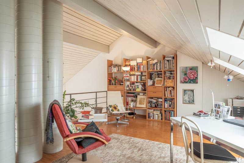 room with ceiling lamp, bookshelves, window seat, a rug, armchairs, white desk, white chair