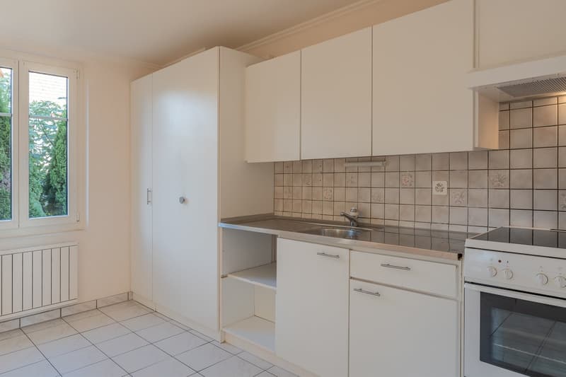 modern kitchen with white cabinets, stainless steel countertop, sink, faucet, electric stove, oven, tiled floor, window