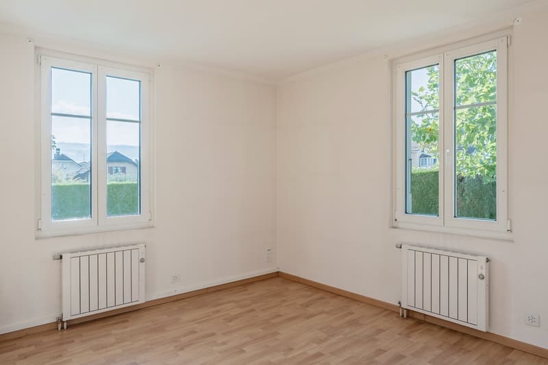 empty room, wooden floor, white walls, two windows, white radiators