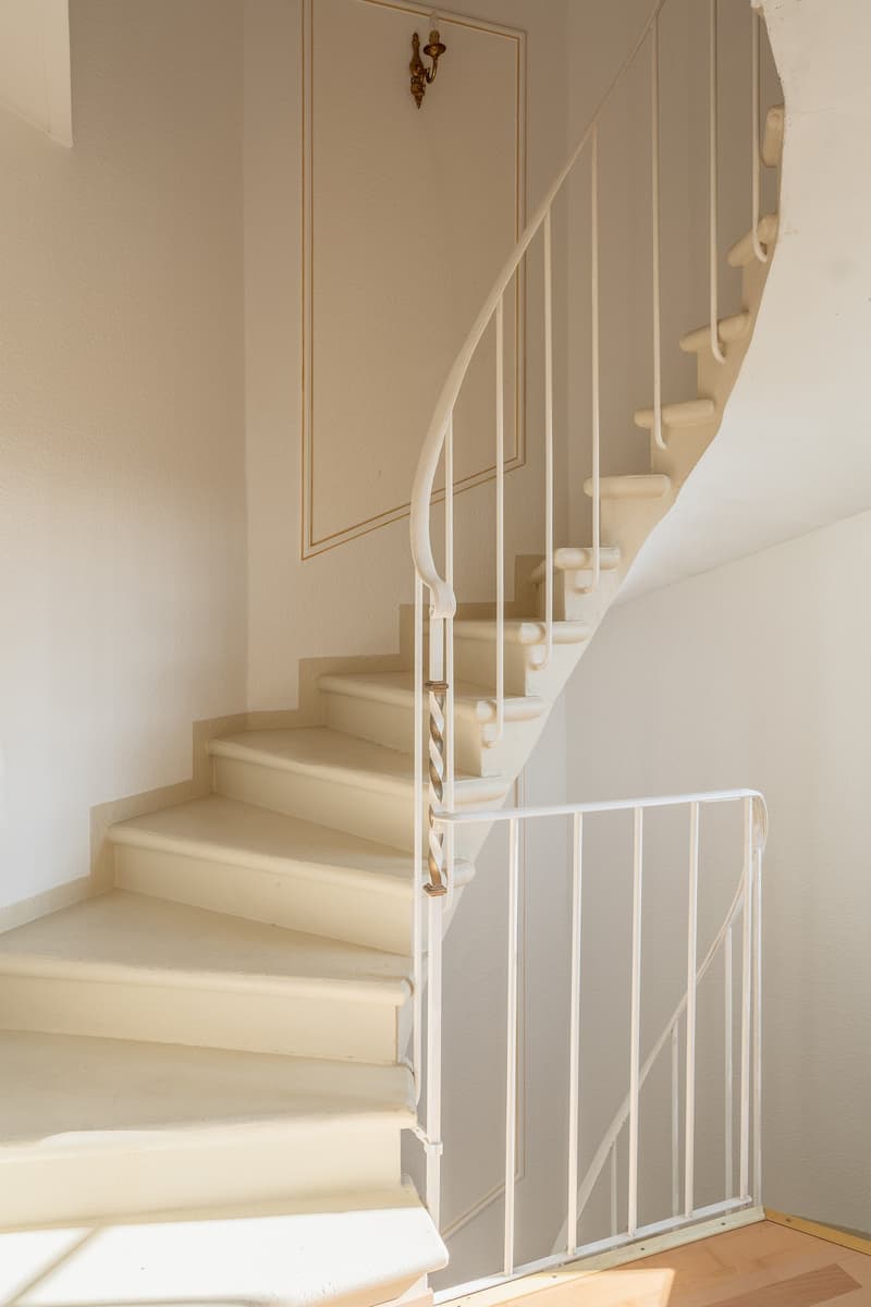 white marble steps, white handrail, wooden floor
