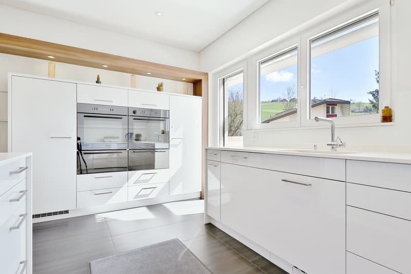 modern kitchen, stainless steel appliances, white cabinets, wooden countertops, ceramic flooring, bright windows