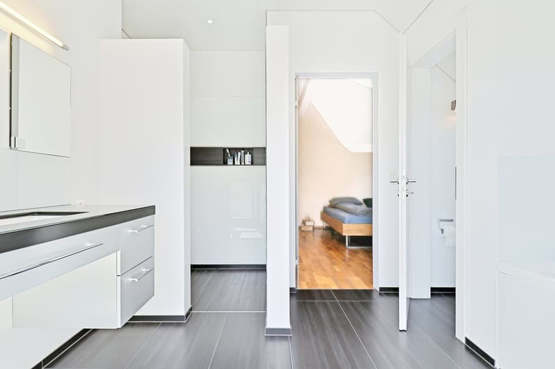 white cabinets, dark wood floors, modern, open bathroom with a bedroom