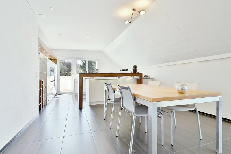 open dining room, white walls, ceiling lamps, grey floor, wooden table, white chairs