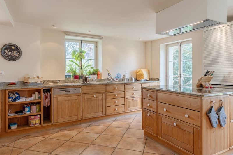 modern kitchen with wooden cabinets, granite countertops, dishwasher, large windows, tiled floor