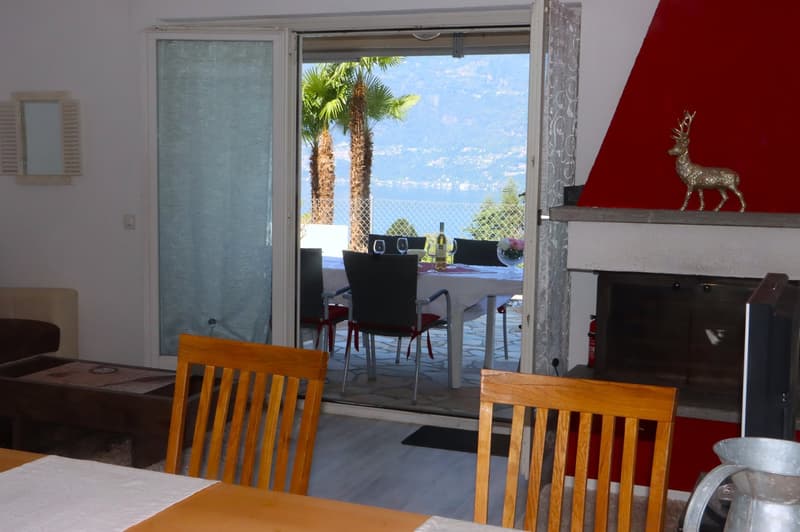 wooden chairs, table, fireplace, balcony with lake view