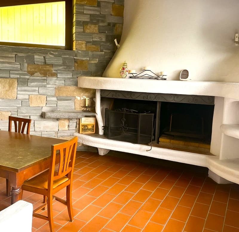 fireplace, orange tiles, stone wall, wooden table, wooden chairs