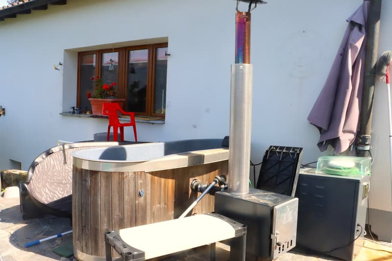 wooden hot tub, heater with chimney, cover, small red chair