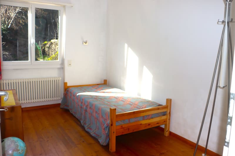 single bed, wooden floor, white walls, window, radiator, globe