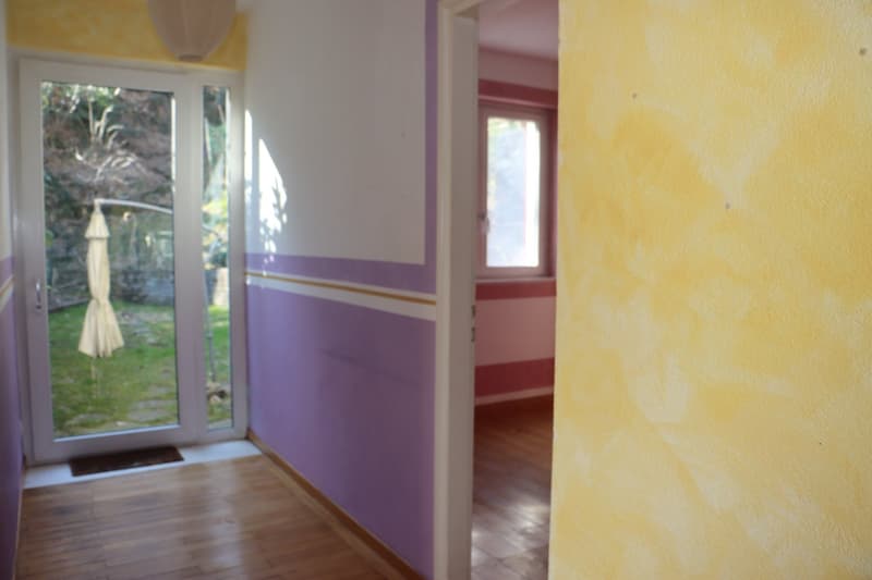 wooden floor, glass door, yellow and purple walls, small window