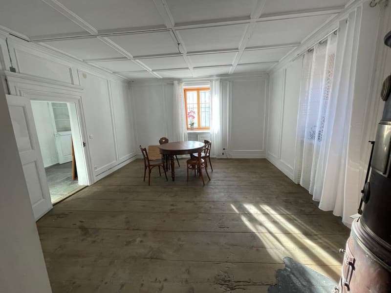 empty room, wooden floor, white walls, wooden table and chairs, fireplace