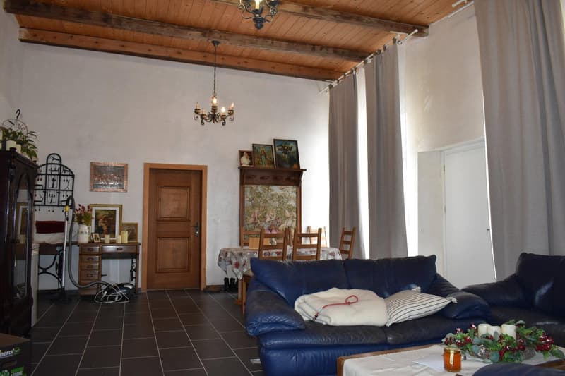 wooden ceiling, two sofas, wooden door, chandelier, dining table and chairs, wooden cabinet, desk, curtain, picture frames, candle, flower vase