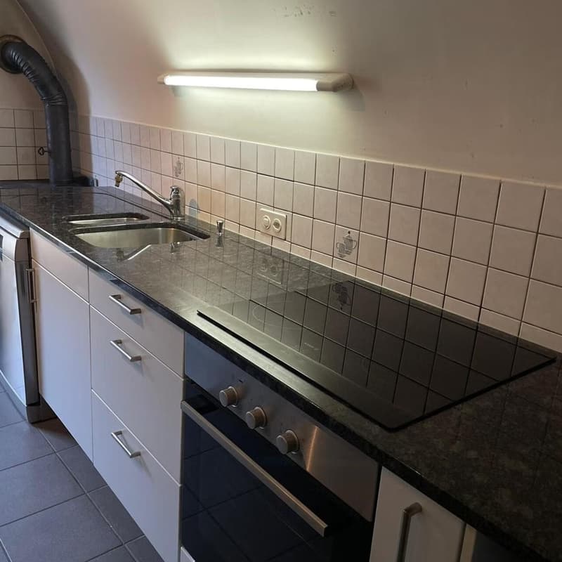 Kitchen, with oven, sink, cabinets, tiled walls, light fixture