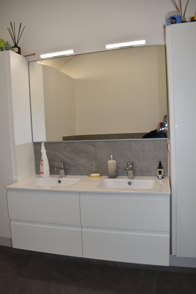 bathroom, white double sink, large mirror, two cabinets, under mirror lighting, white tiles on walls