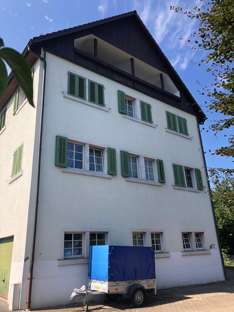 3 story house, white exterior, green shutters, balcony on second floor, trailer parked in front