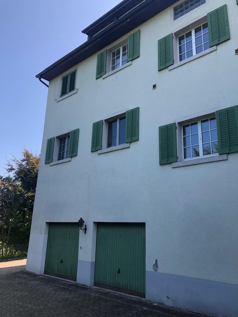 3 story house, white walls, green shutters, 2 garages
