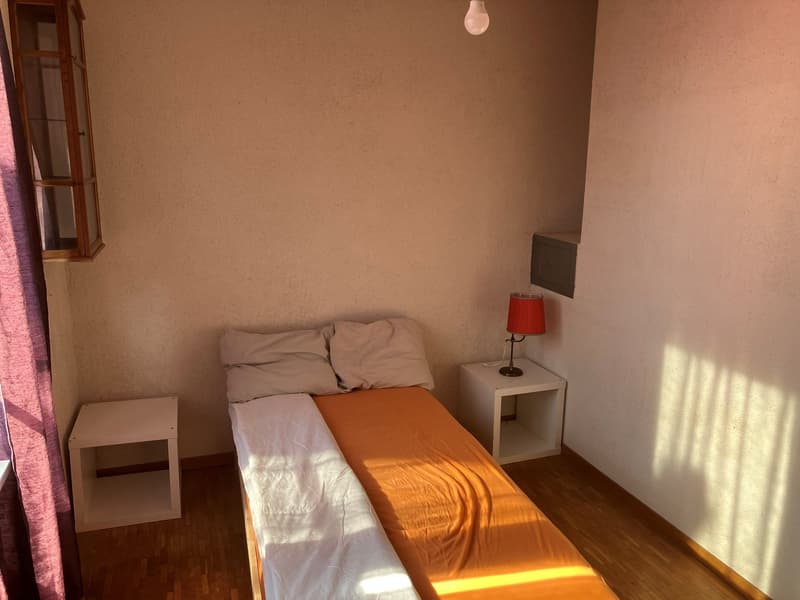small bedroom with bed, nightstands, lamp, and window