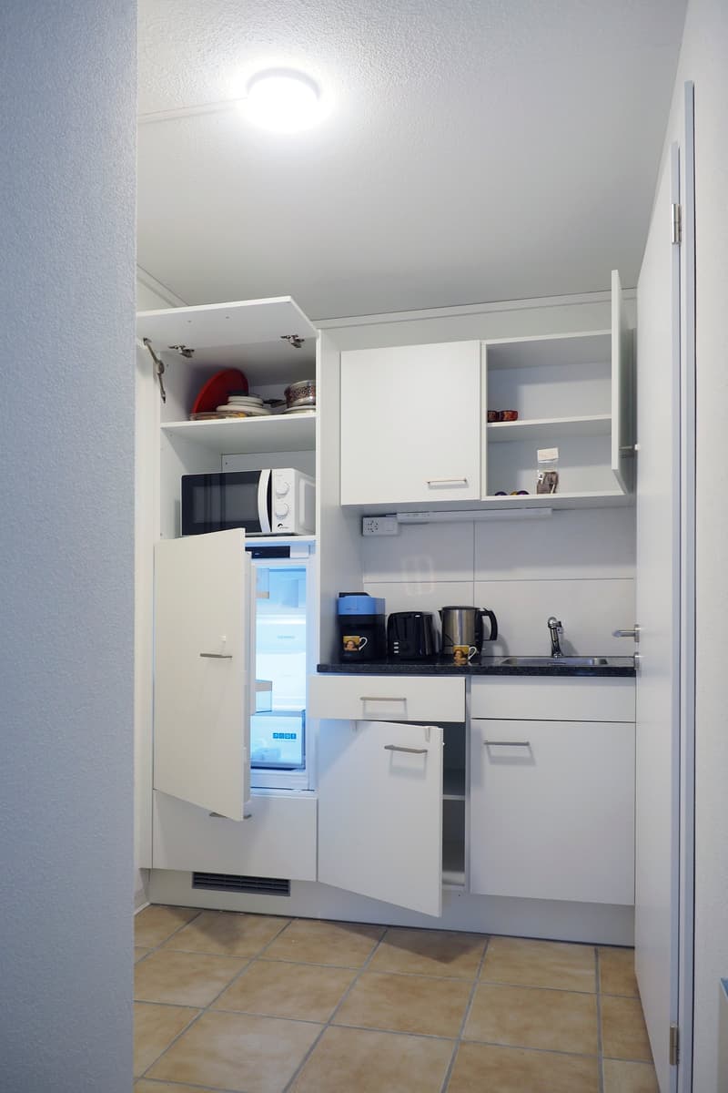 modern white kitchen, open refrigerator, microwave, toaster, sink with faucet, gas stove, cabinets and drawers, coffee machine, kettle