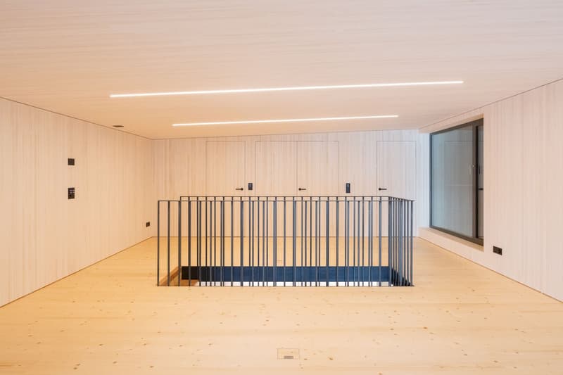 empty room, wooden floor, white walls, metal railing, glass window, two doors